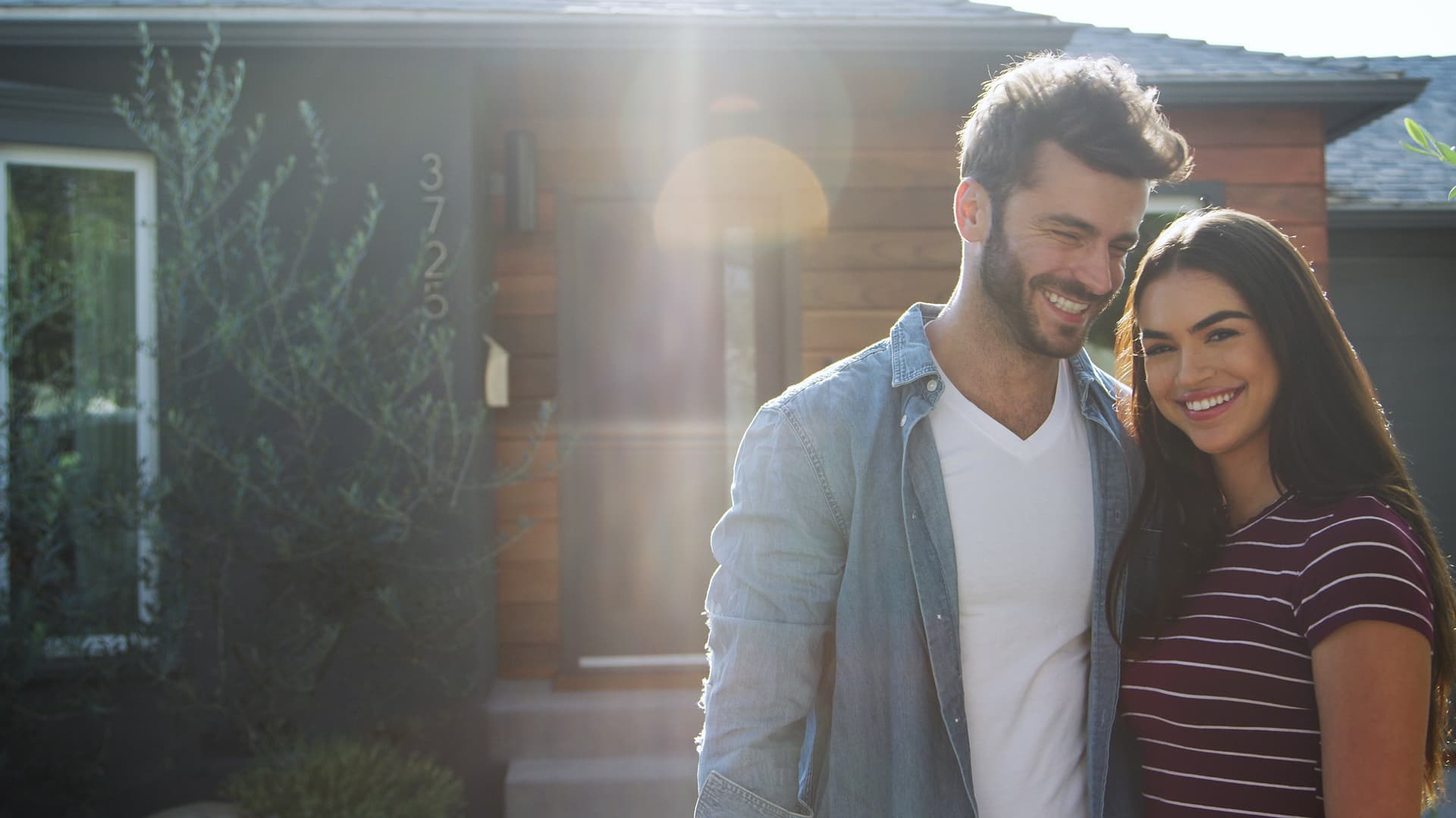 Couple in front of their new home