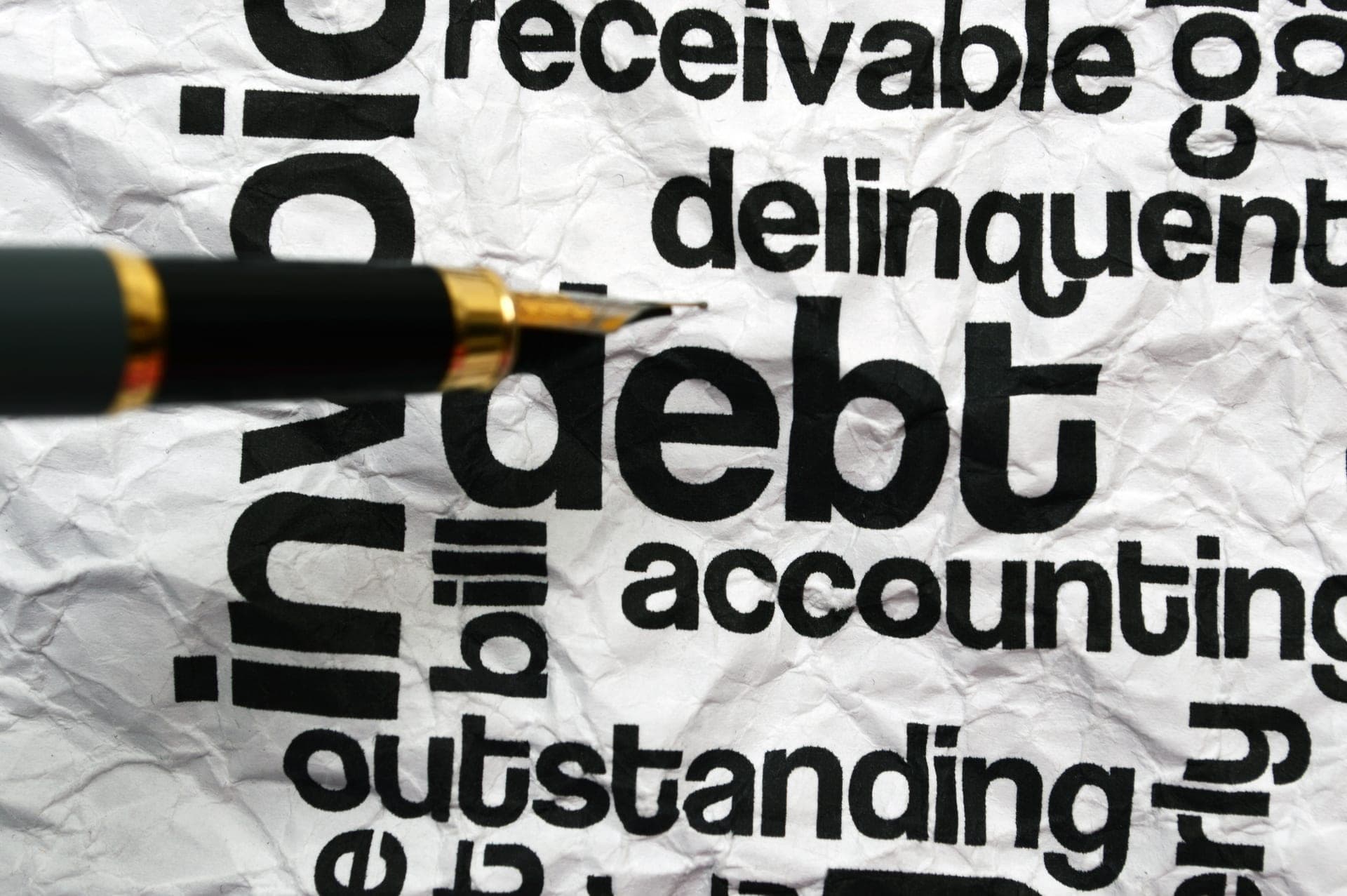 Debt concept written on a surface with financial paperwork nearby