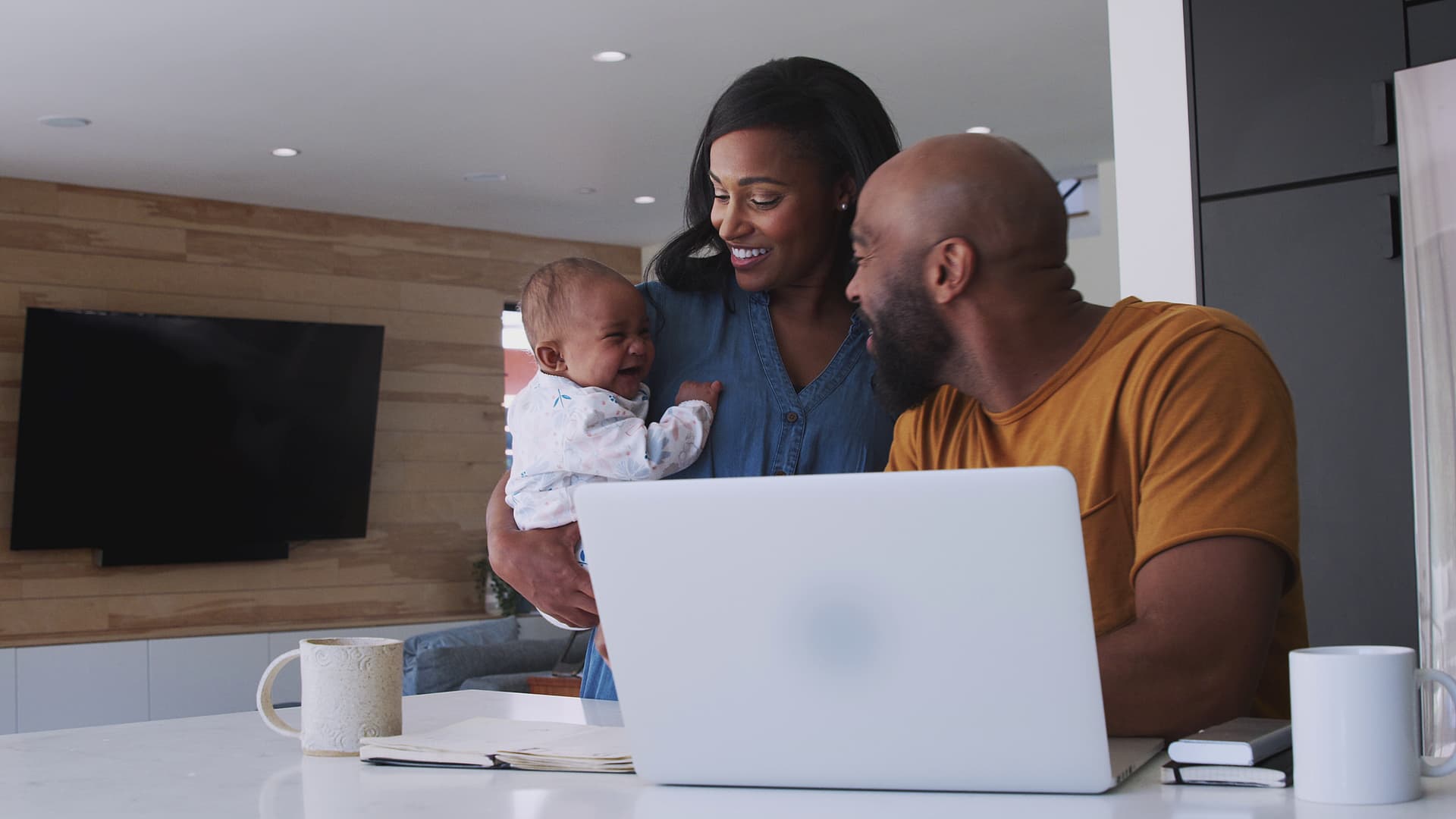 Family with baby using laptop to check finances