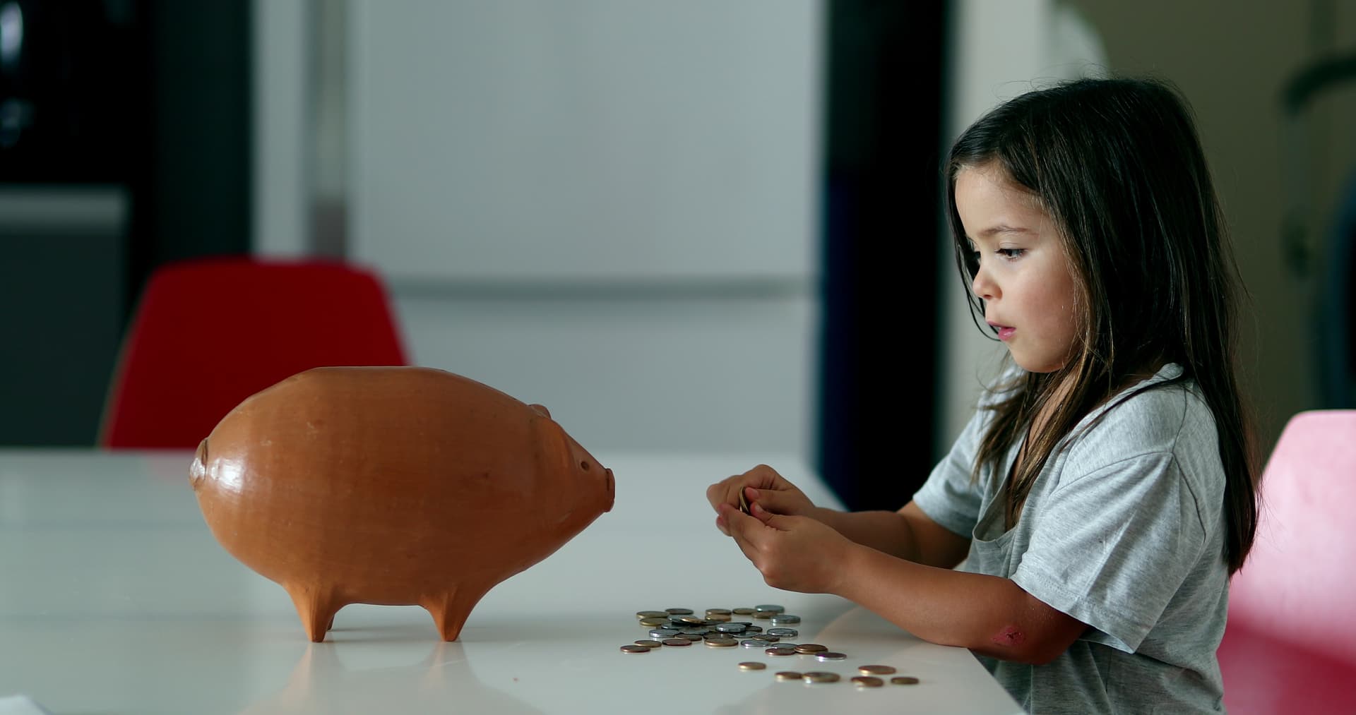 Child learning about saving with piggy bank
