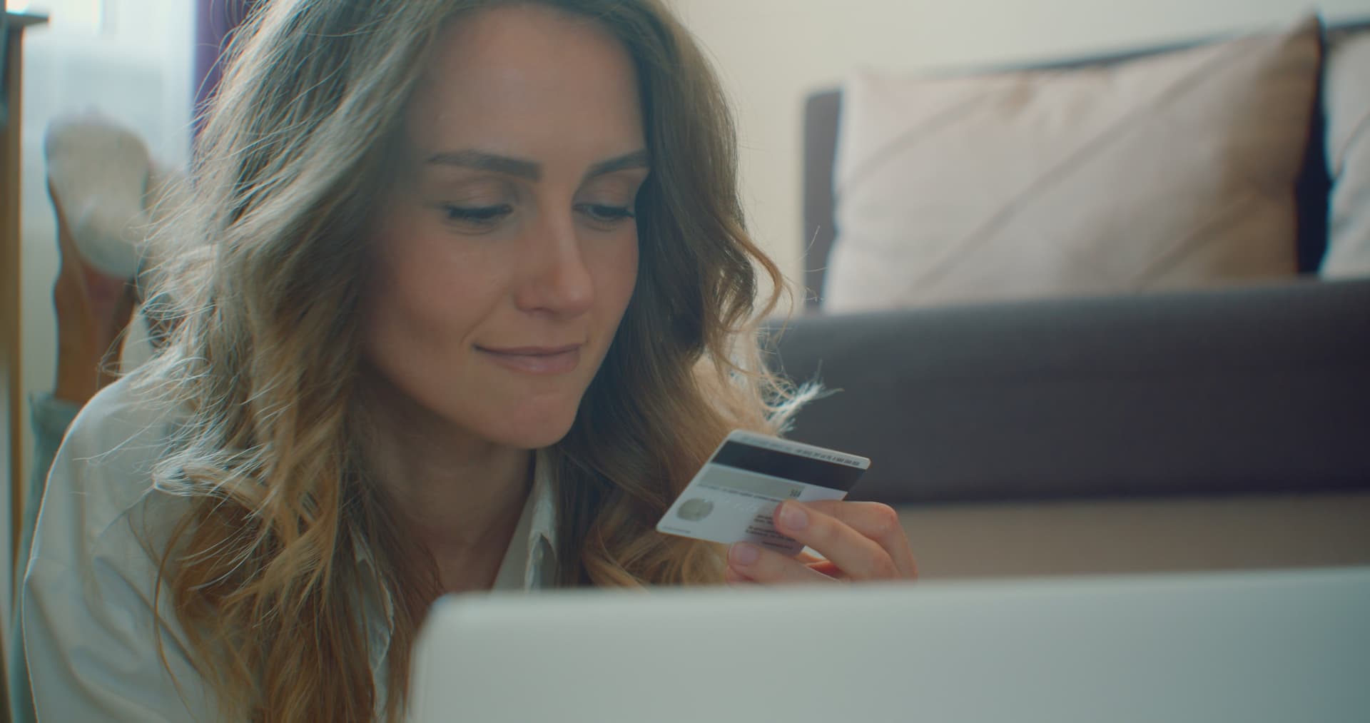 Woman using laptop with credit card for online banking