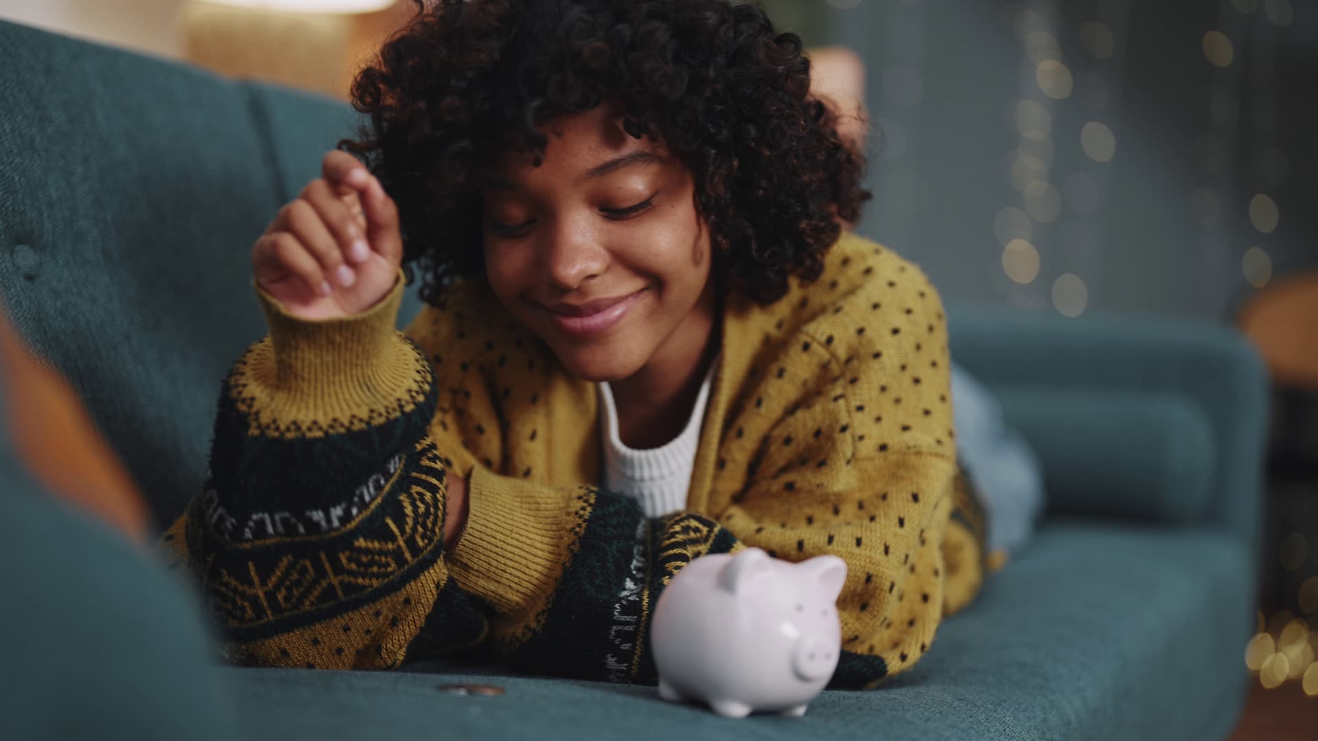 Happy woman adding coins to piggy bank with a smile