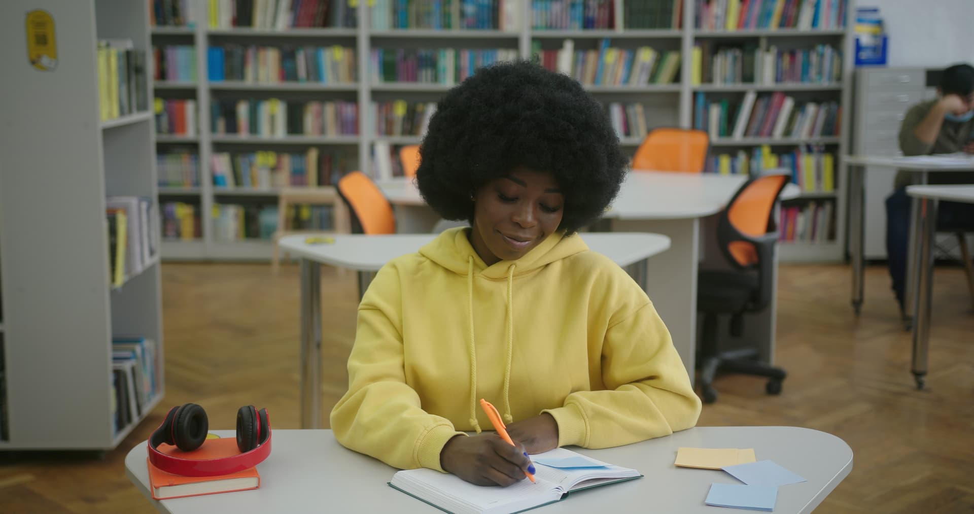 Young woman writing financial goals in a notepad