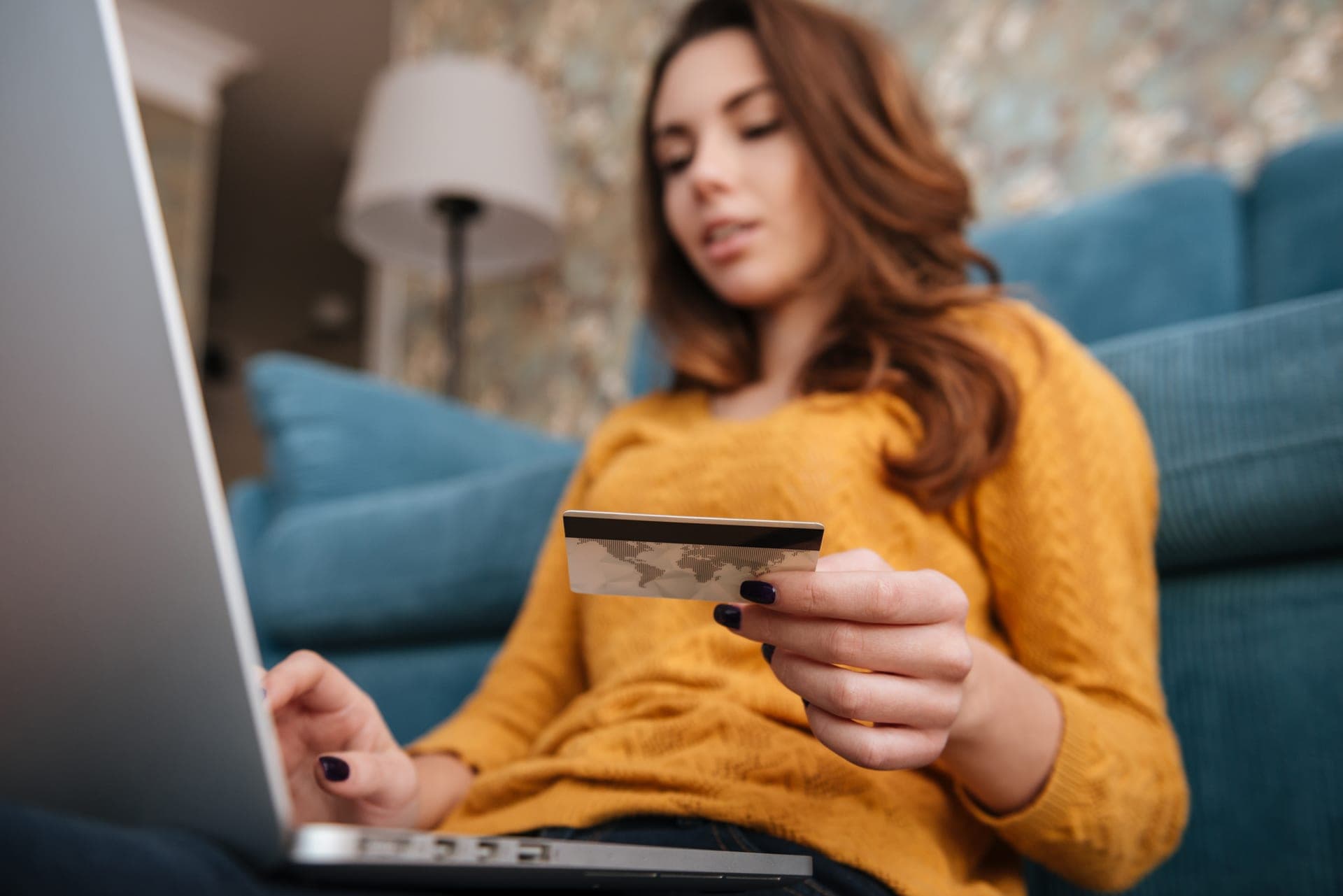 Smiling woman with laptop and credit card, comparing banking options